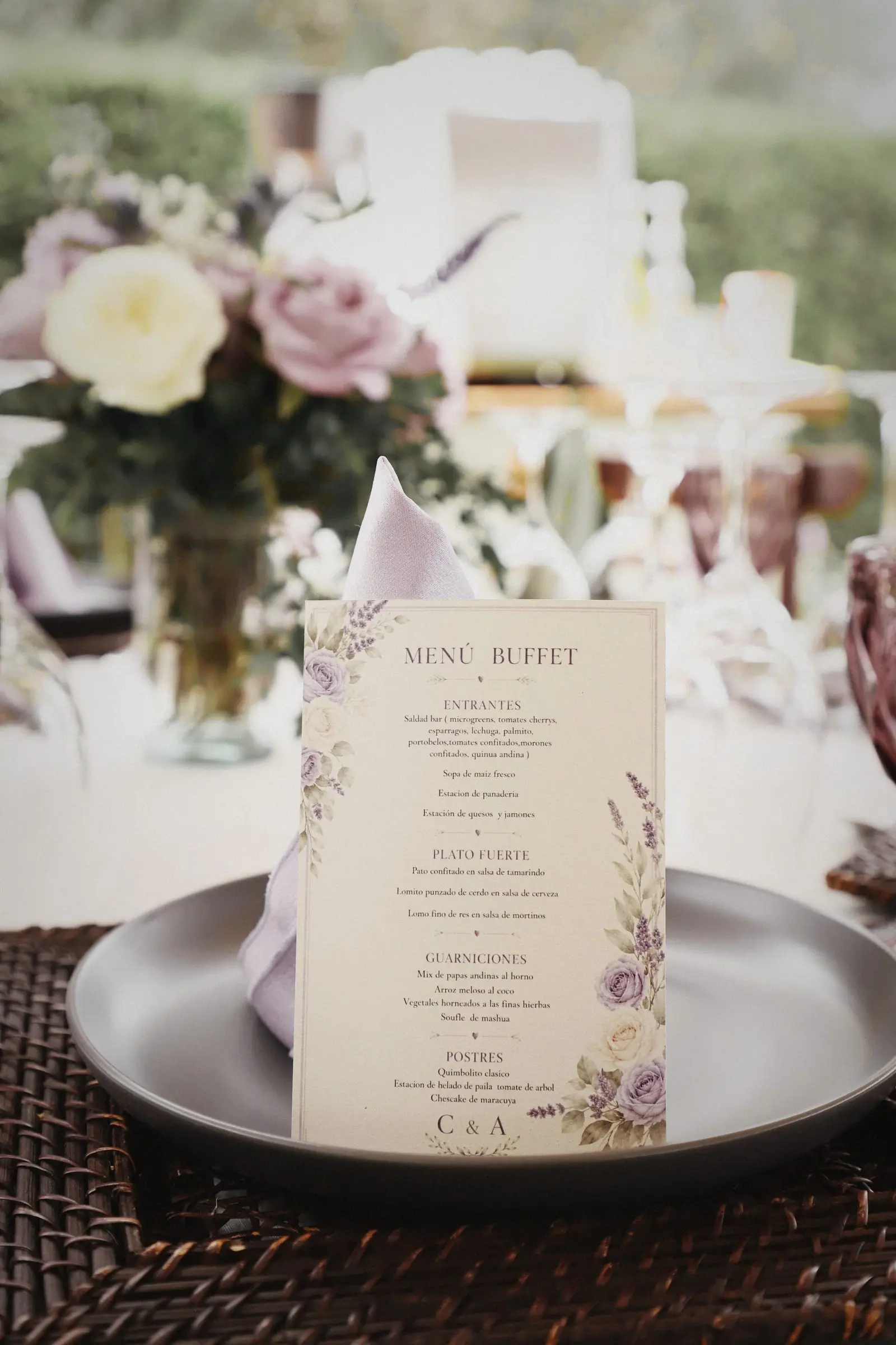 A printed buffet menu resting on a plate, flowers behind.